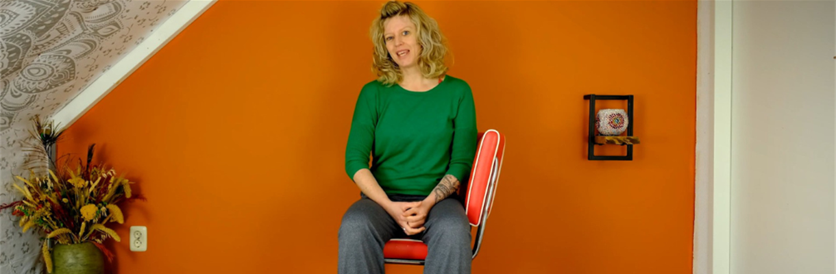 Manon zit op een stoel klaar voor yoga
