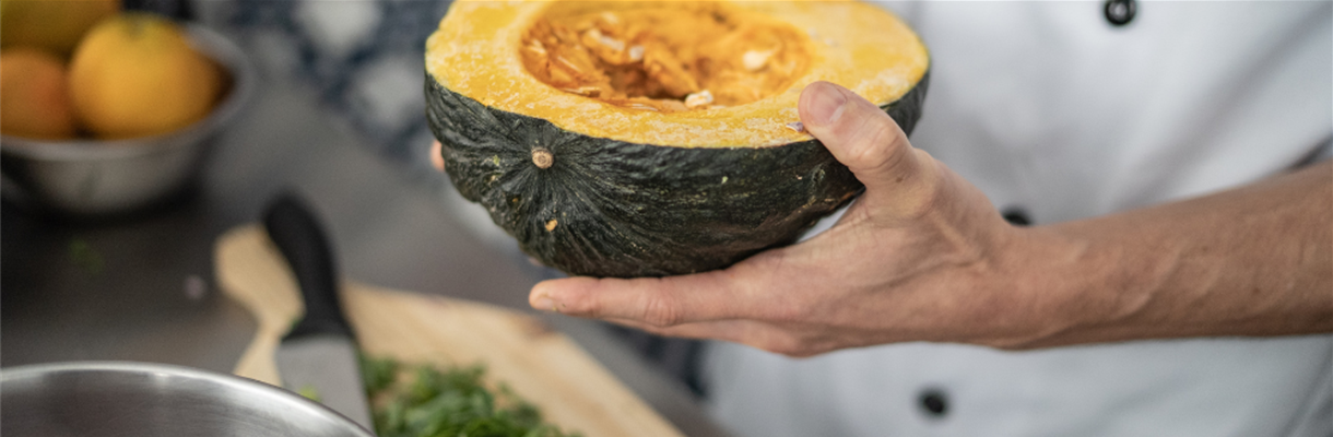 Man houdt gesneden pompoen vast