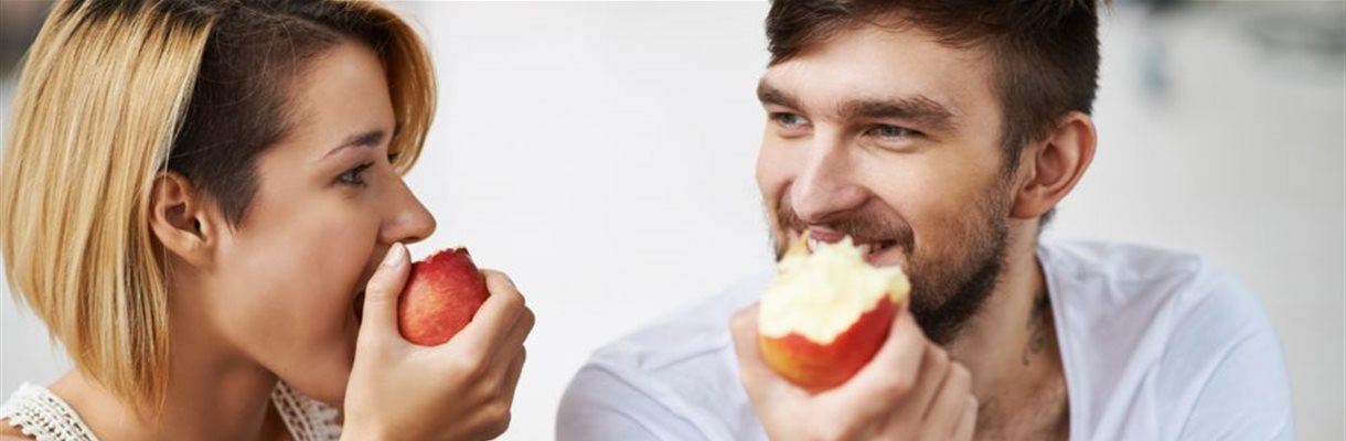 Vrouw en man eten allebei een appel