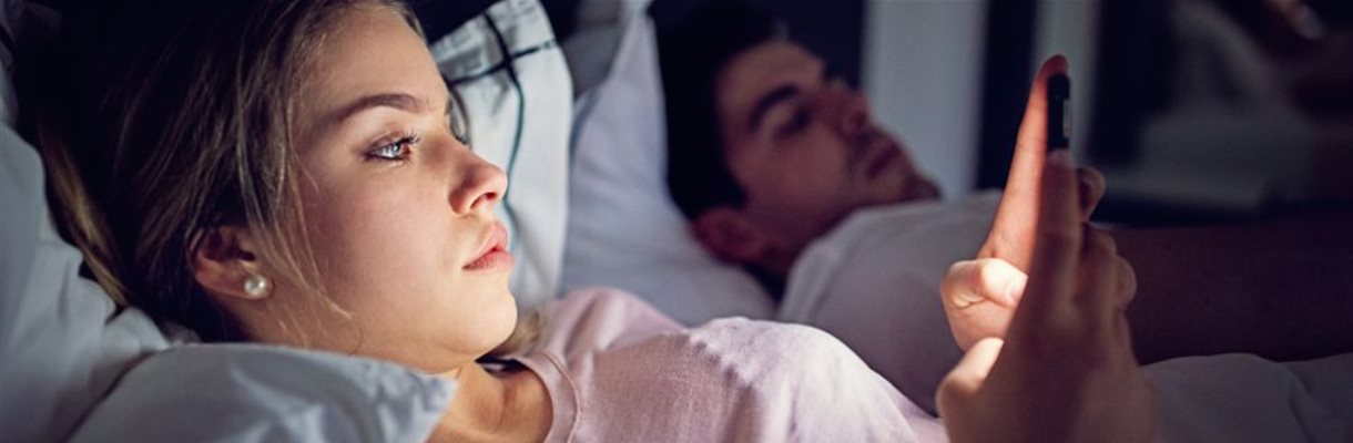 mevrouw in bed met telefoon