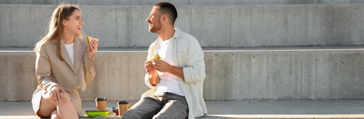 Vrouw en man die buiten aan het lunchen zijn