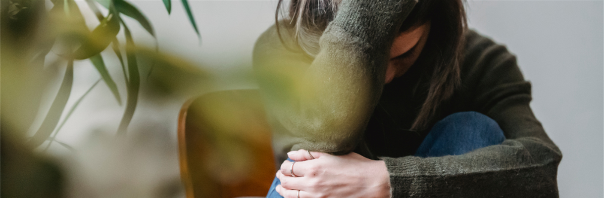 Vrouw zit op een stoel en hikt tegen een burn-out aan