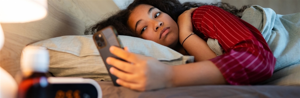 Vrouw ligt in bed kijken op haar telefoon