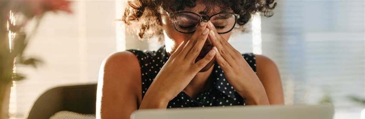 Vrouw met handen in gezicht tijdens de week van de werkstress